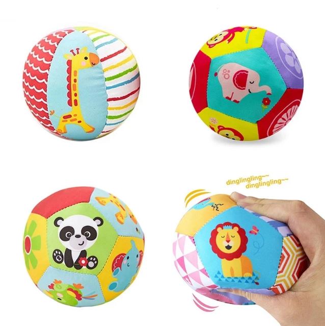 Quatre balles sensorielles en tissu coloré avec des motifs d'animaux comme une girafe, un éléphant, un panda, et un lion.