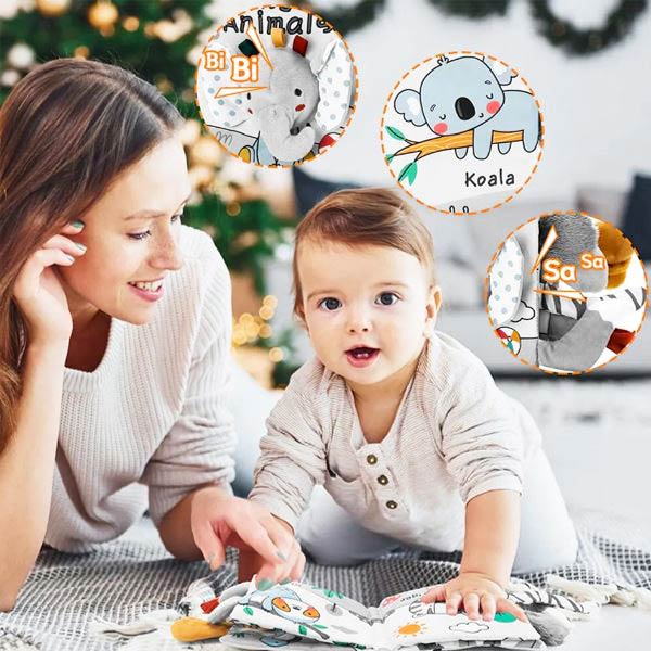 Une mère et son bébé interagissent avec un livre à toucher Montessori, mettant en scène des animaux comme un éléphant et un koala, avec des éléments tactiles et sonores pour stimuler les sens de l'enfant.