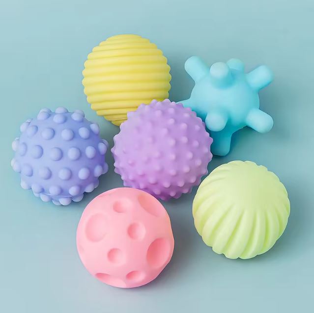 Lot de 6 balles sensorielles aux textures variées et aux couleurs pastel, conçues pour stimuler les sens des bébés.