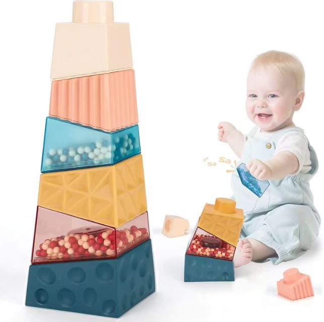 Bébé jouant avec des cubes à empiler montessori de différentes textures et couleurs, conçus pour stimuler la motricité fine et la coordination tout en encourageant l'exploration sensorielle.