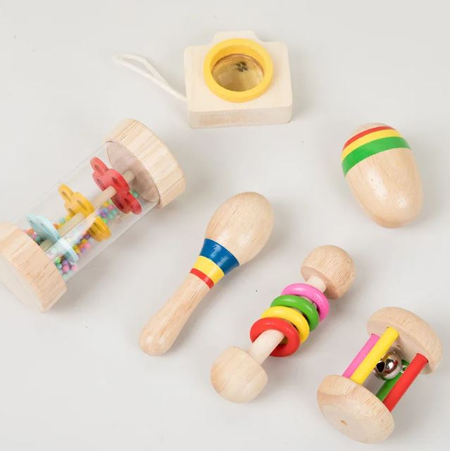 Set musical avec différents instruments colorés, incluant un shaker, un kaléidoscope et des hochets, idéal pour stimuler la coordination et l’éveil musical.