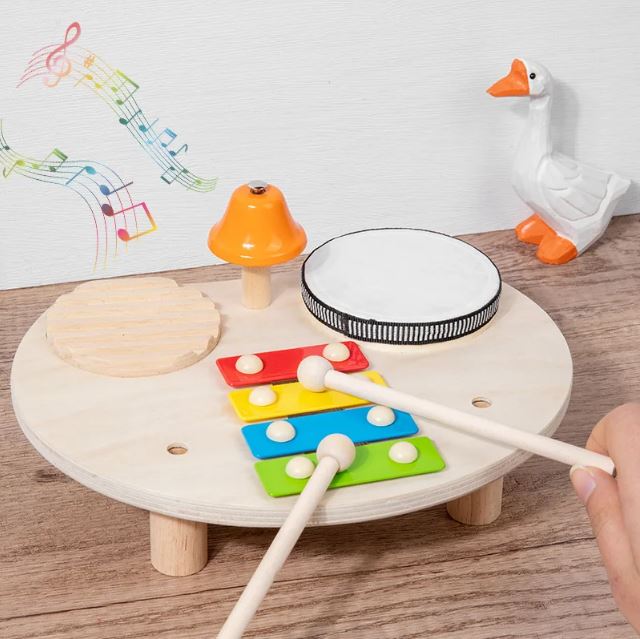 Table musicale Montessori en bois avec xylophone, cloche et tambour, favorisant l'éveil musical des tout-petits.