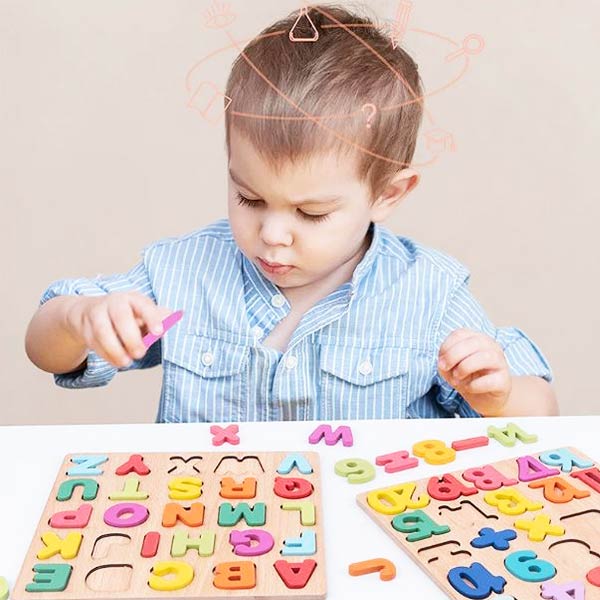 Enfant jouant avec un puzzle alphabet en bois coloré pour apprendre les lettres.