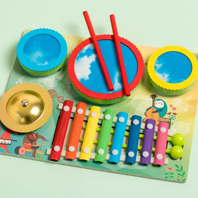 Table d'activité musicale bébé en bois avec xylophone coloré, tambours et cymbale.