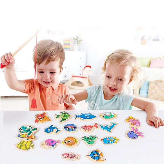 Deux enfants jouent avec un jeu de pêche magnétique en bois, utilisant des cannes aimantées pour attraper divers poissons colorés, parfait pour développer la motricité fine et la coordination tout en s'amusant.