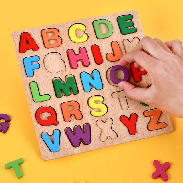 Puzzle alphabet en bois avec des lettres colorées, montrant une main qui place la lettre O dans son emplacement.